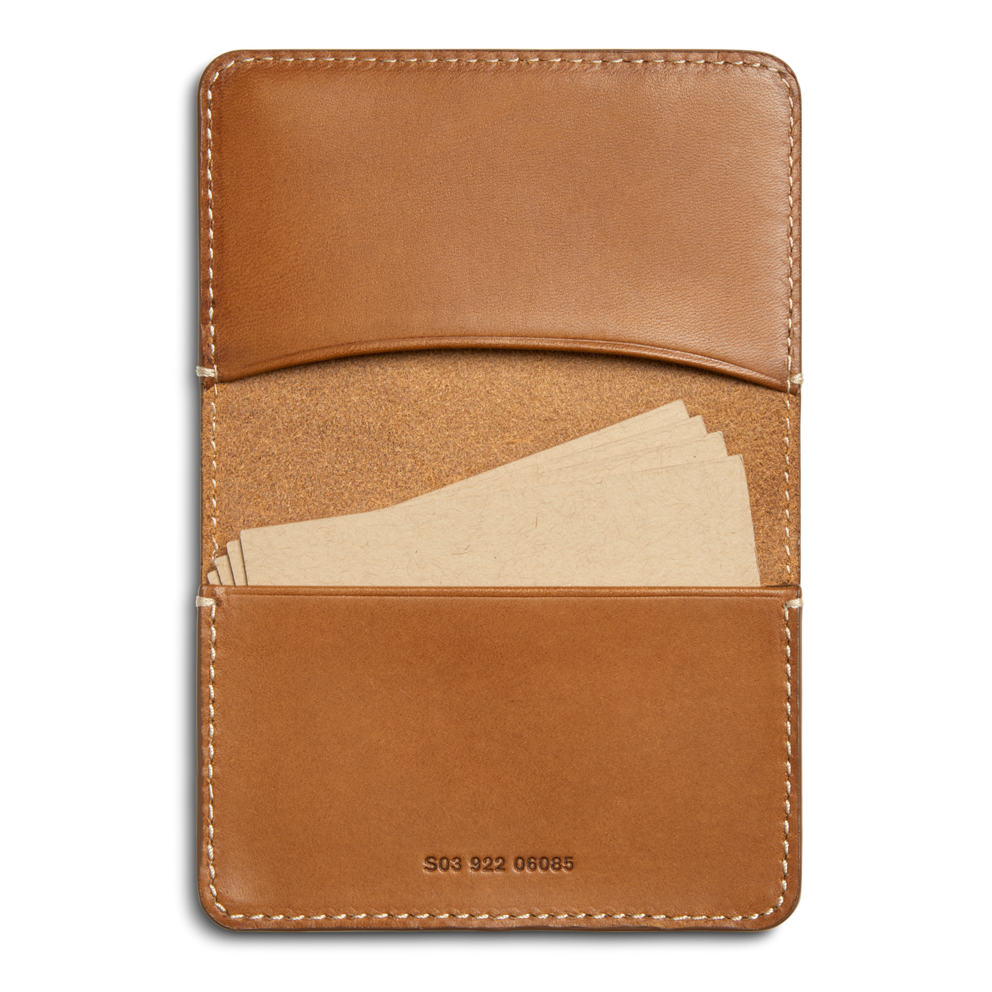 The Shinola Business Card Holder - Tan features Italian Vachetta leather with visible stitching, two pockets, a serial number on the bottom, and holds several blank beige cards. It’s ideal for monogramming.
