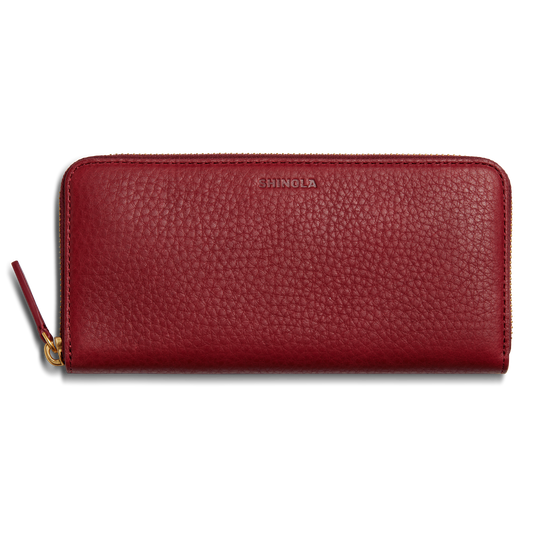The Continental Zip Wallet - Ruby by Shinola is crafted from natural grain leather with a textured finish, card pockets, and a gold zipper pull. SHINOLA is embossed near the top center.
