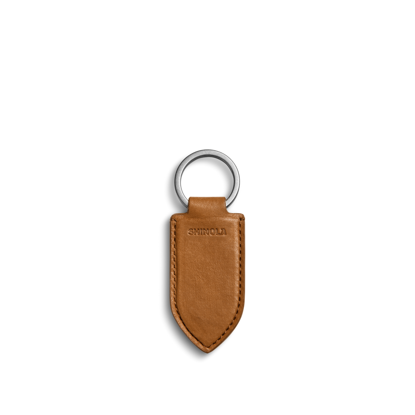The Leather Monogram Key Fob - Tan by Shinola is a brown leather keychain with a pointed tip, silver metal ring, and the word SHINOLA embossed in the center, shown on a plain white background.
