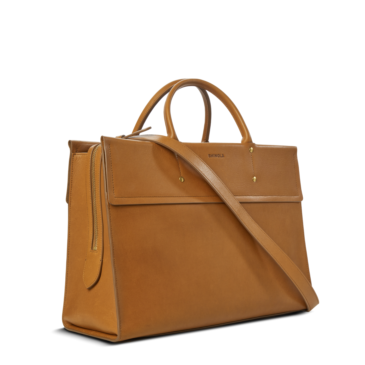 The Shinola Day Satchel - Tan features top handles, a front flap, gold hardware, an adjustable shoulder strap, and a laptop compartment—making it a stylish and organized choice for on-the-go use.