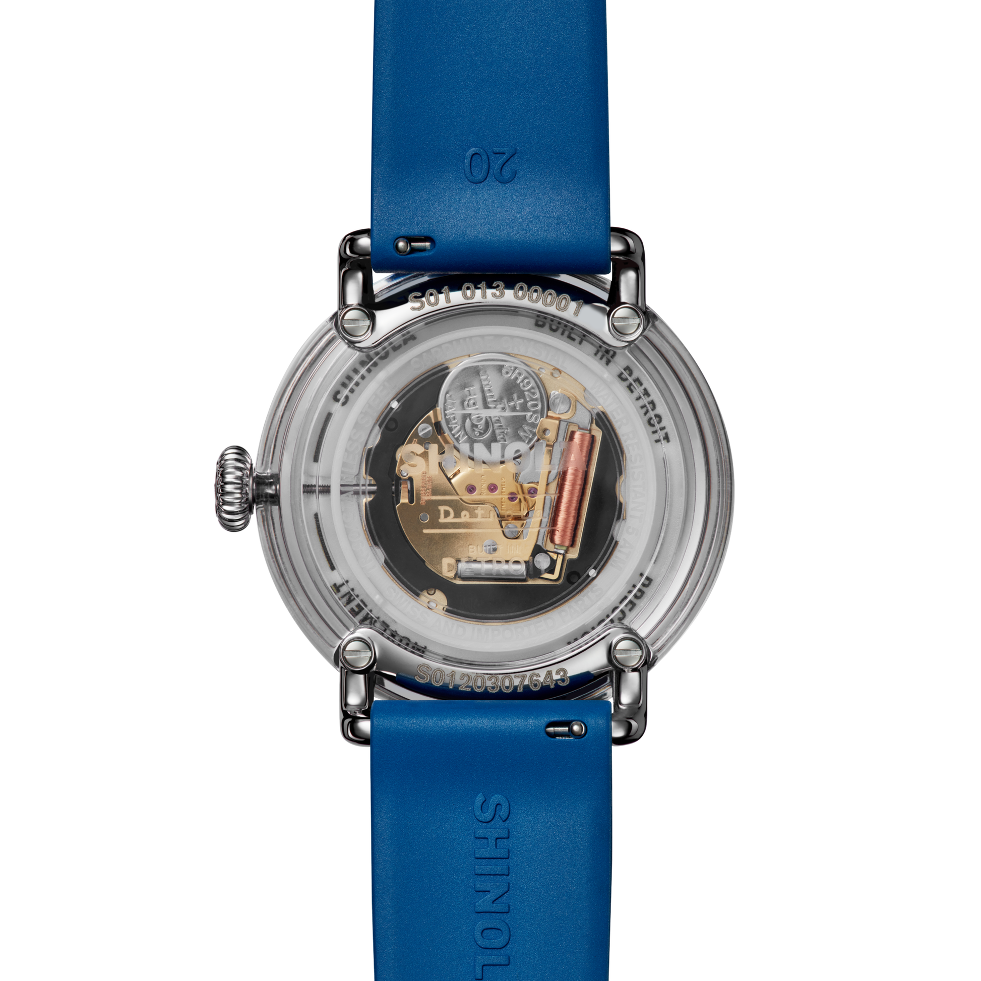 A close-up of the transparent back of the Shinola Detrola Watch - Denim Blue, revealing its internal mechanical components and intricate gears, with blue leather straps displaying the Shinola brand name.
