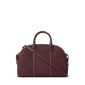 The Shinola Runwell Satchel - Merlot is a structured, dome-shaped women's crossbody with two handles, a detachable strap, gold-tone hardware, and subtle embossed branding on the front.