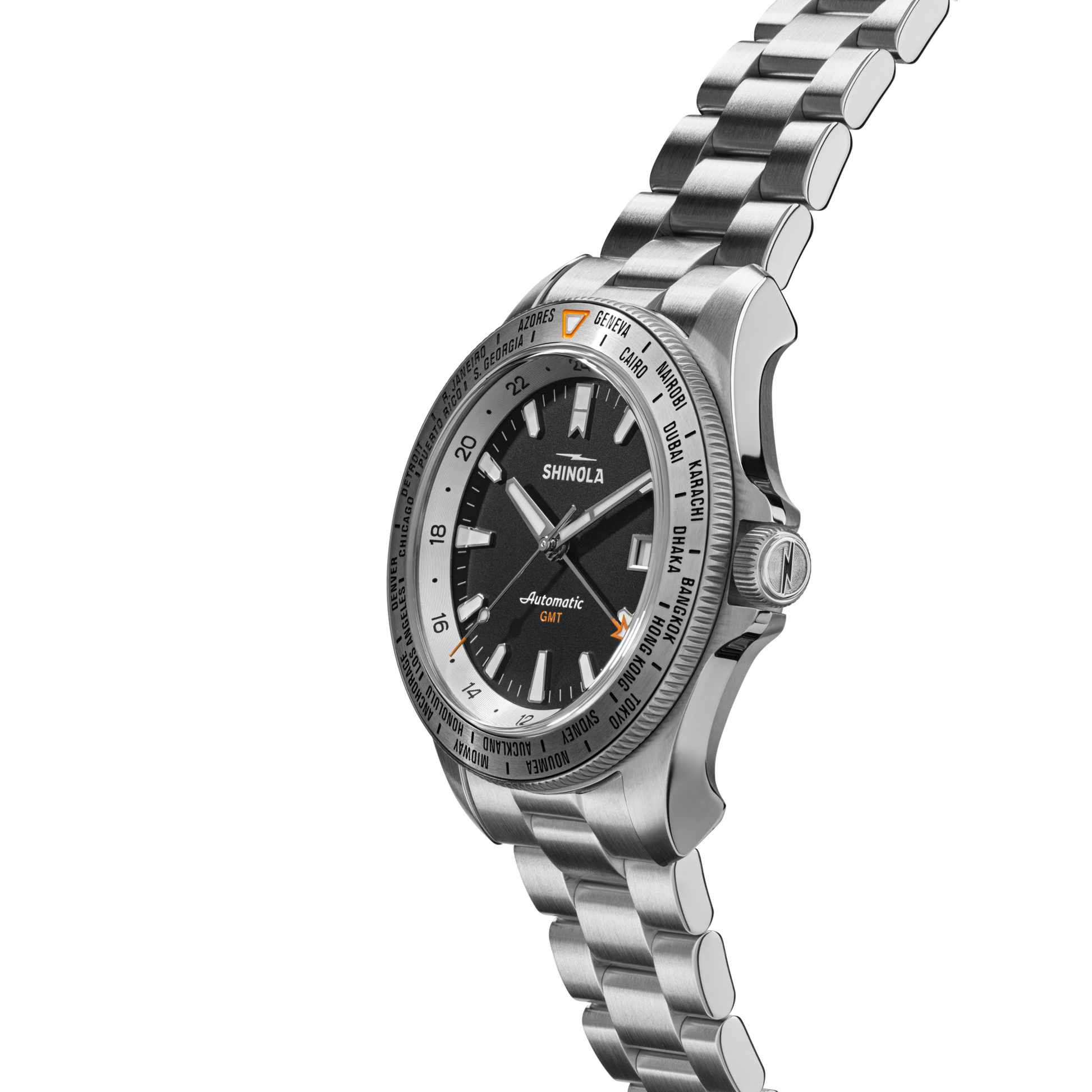 The Shinola Monster Worldtimer GMT Watch features a black dial, silver hour markers, metal link band, orange-tipped GMT hand, rotating 24-hour scale, and world timer bezel. Pictured on a plain white background.
