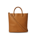The Shinola 12 Hour Tote Bag in tan features two top handles, a long adjustable shoulder strap, and an interior pocket for organization. "Shinola" is embossed near the bottom center and it's displayed on a plain white background.