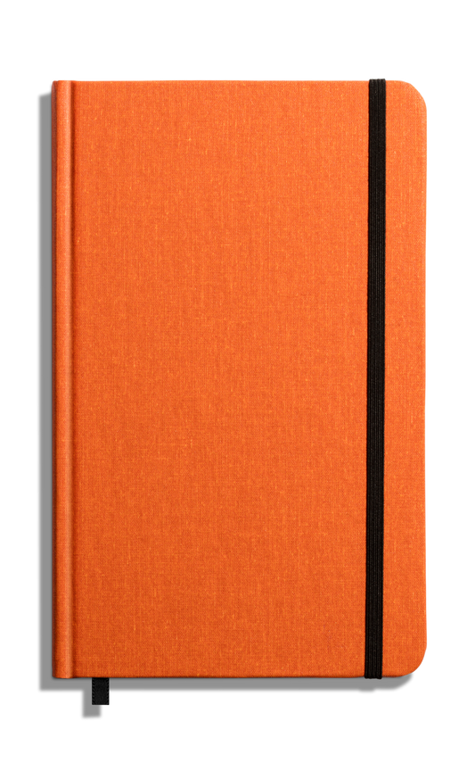 The Shinola Medium Hard Ruled Journal in Bold Orange features a closed orange hardcover, black elastic band, and matching orange ribbon bookmark, photographed on a plain white background.