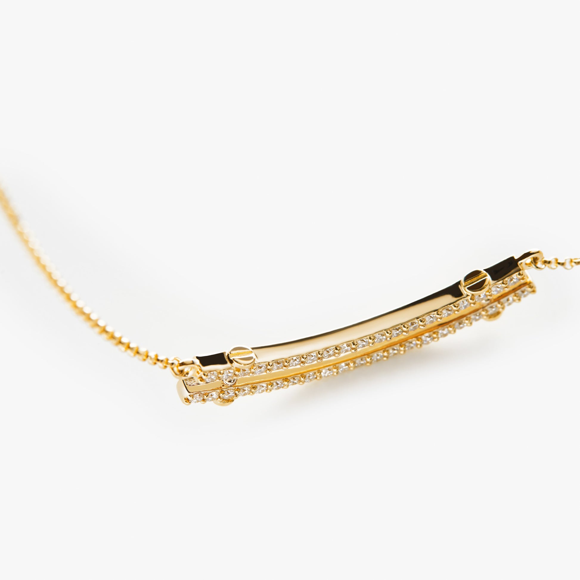 Close-up of the Diamond Pave Rivet Double Row Necklace by Shinola, crafted in yellow gold with a curved bar pendant encrusted with diamonds, shown against a plain white background.