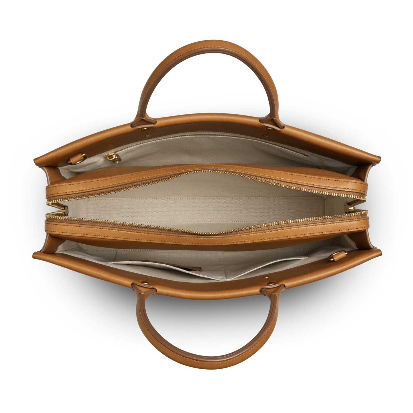 Top view of the Shinola Day Satchel - Tan: a versatile leather bag with two handles, spacious beige fabric interior, dual main compartments (one for a laptop) separated by a zip pocket, and extra small inner pockets.