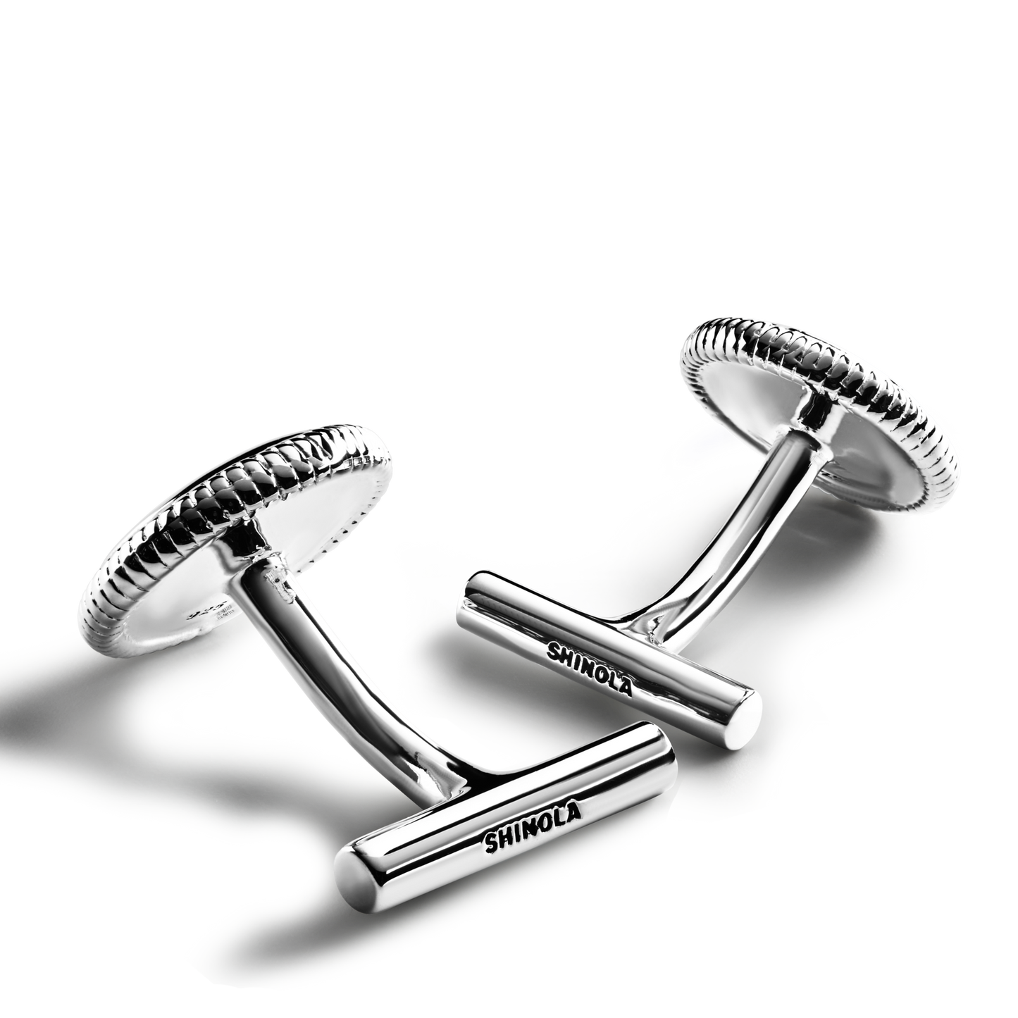 Shinola Coin Edge Cufflinks, crafted in shiny sterling silver with a textured edge and the Shinola name engraved on the bar, are displayed on a light gray background.