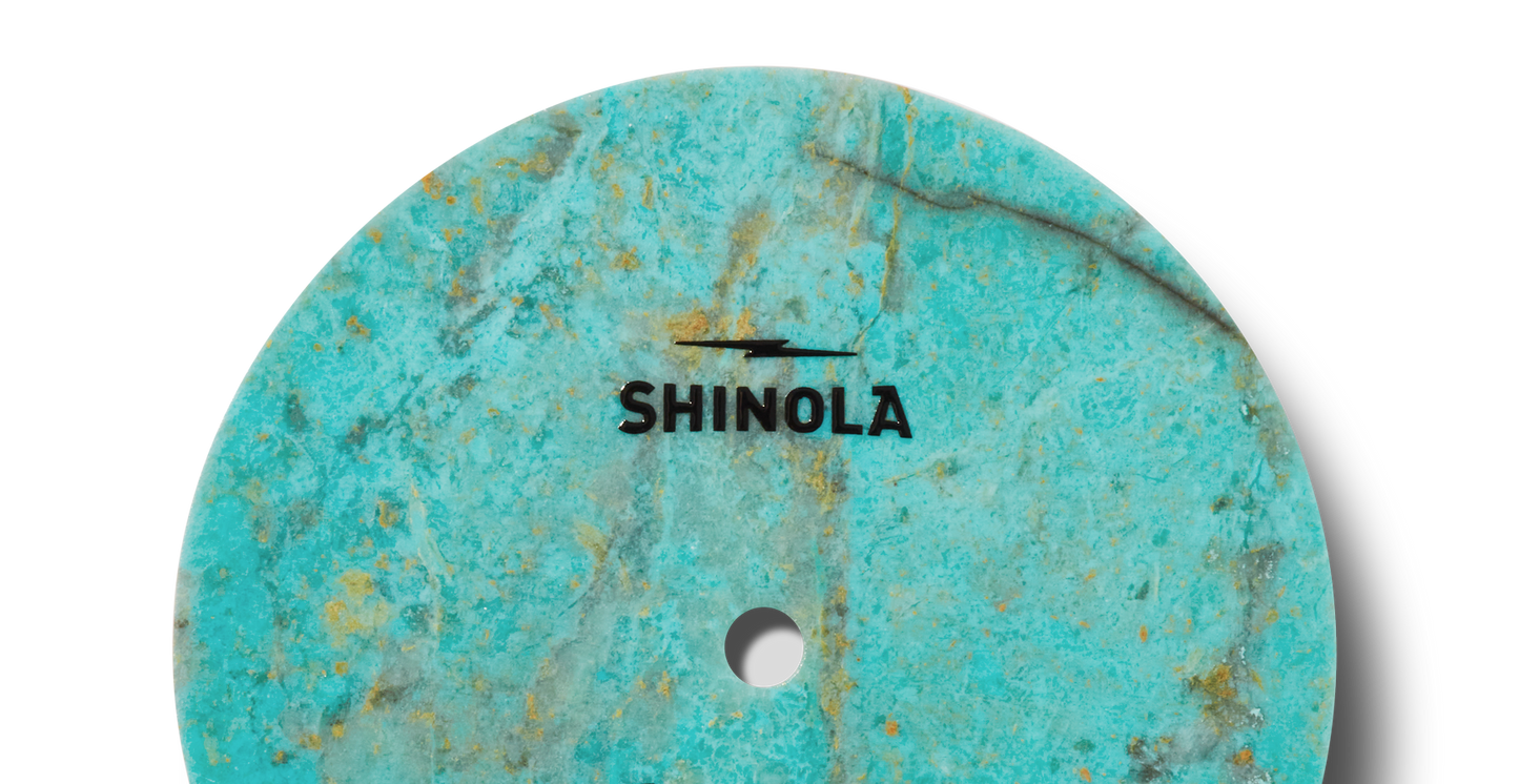 The Shinola Birdy Watch - Chrysocolla features a turquoise and gold marbled circular surface, echoing the signature style of the Birdy Collection.
