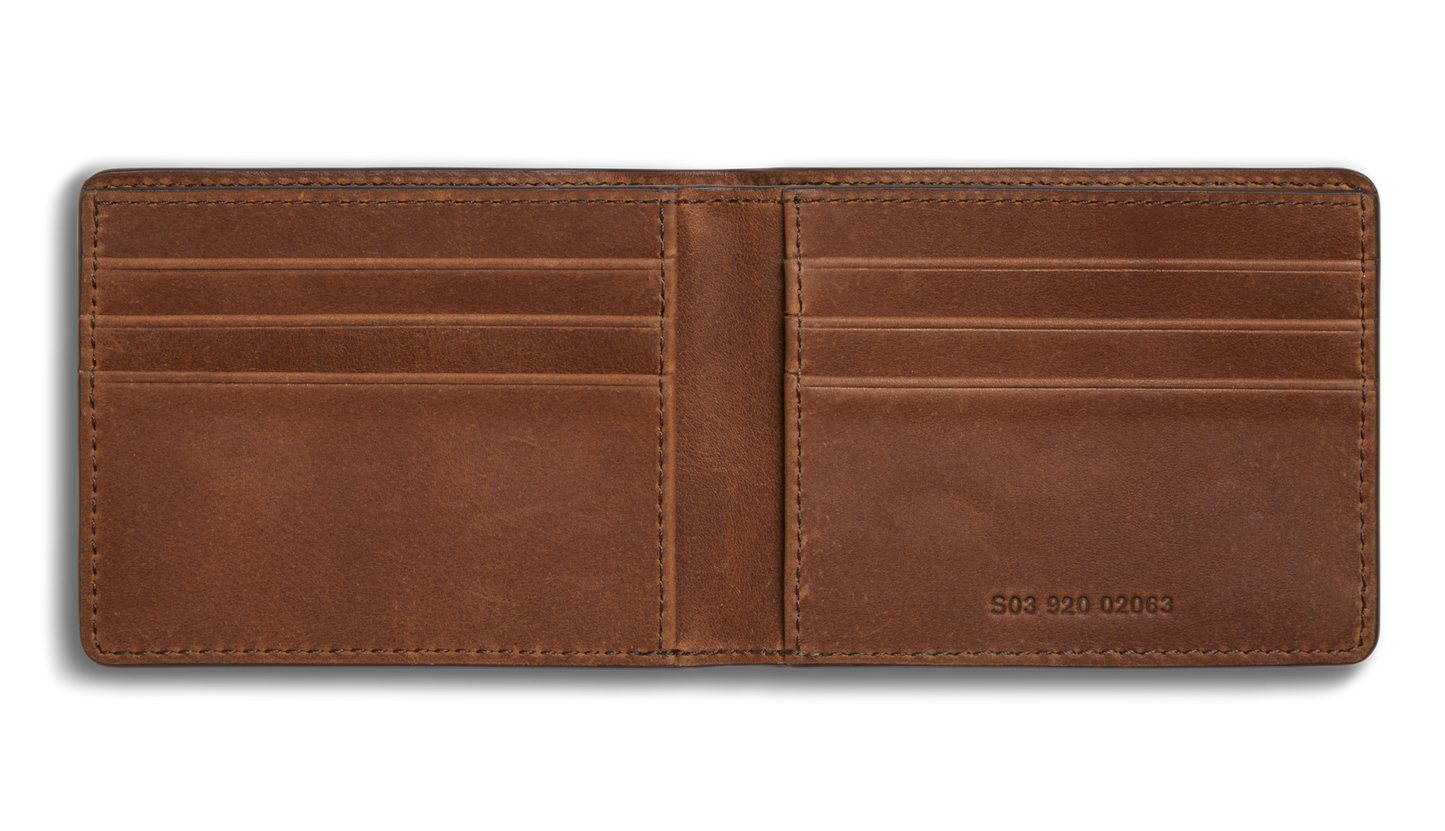 The Shinola Slim Bifold Wallet - Medium Brown features premium leather, six card slots, two spacious pockets, and an embossed number on the bottom right.