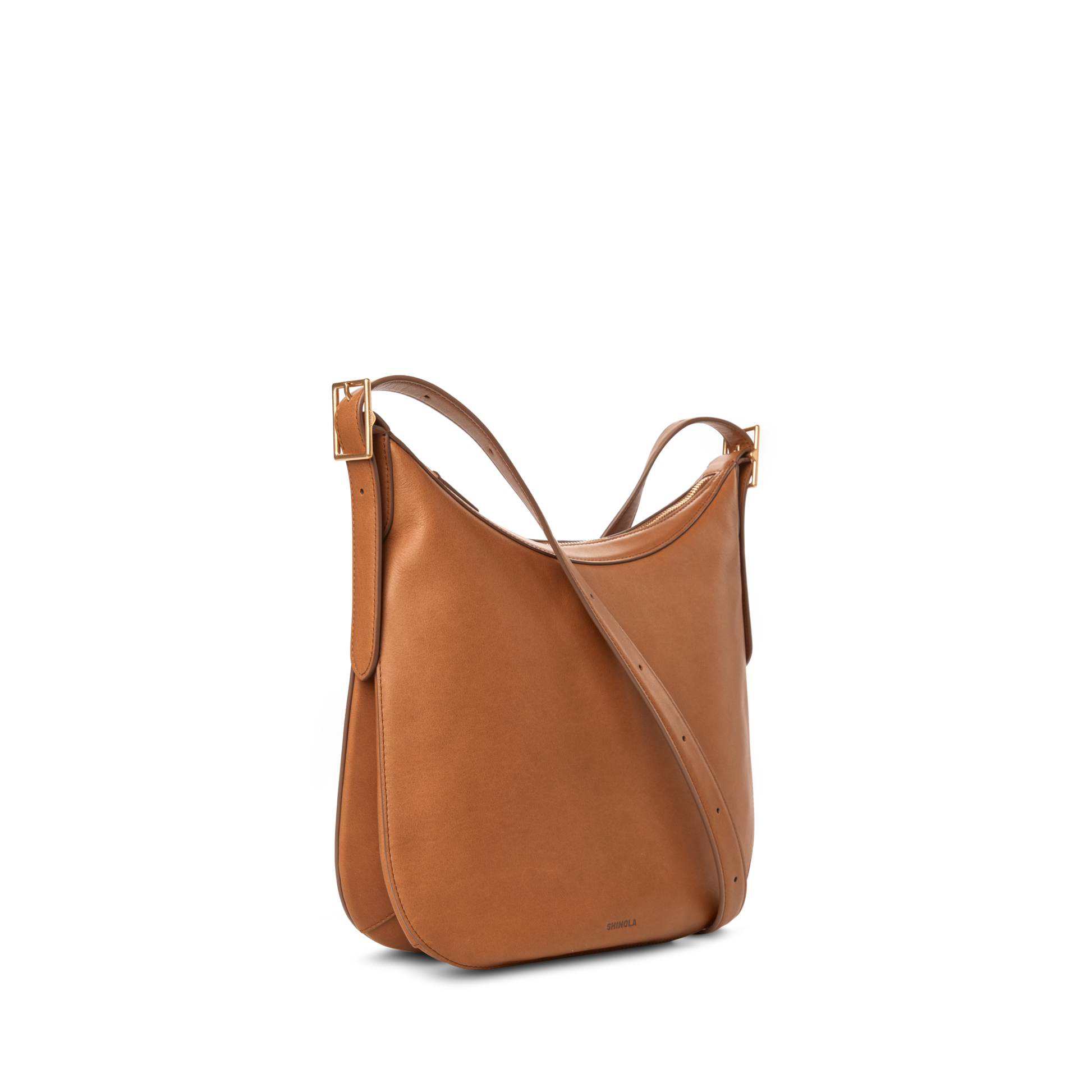 The Shinola Medium Bixby Crossbody - Tan is a natural leather shoulder bag with a curved top, adjustable strap, and minimal design, shown against a plain white background.