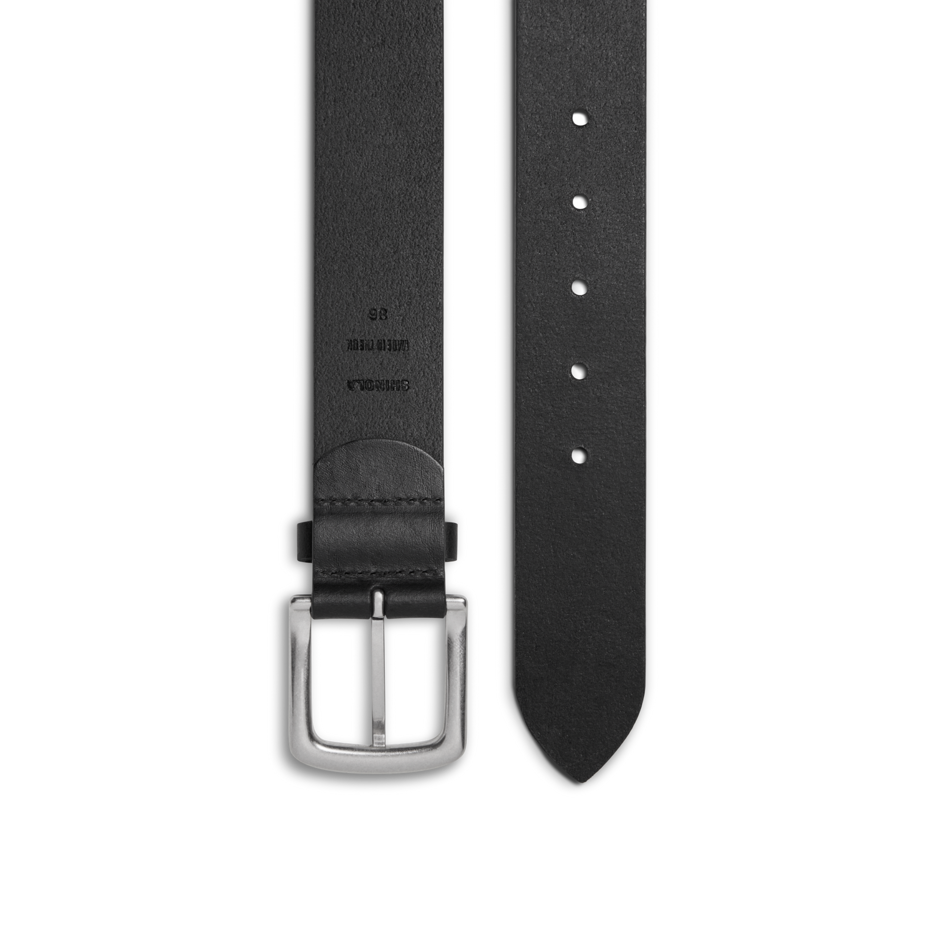 The Shinola 1 1/2" Essential Belt in black natural leather features a silver rectangular buckle, punched holes for adjustable fit, and embossed sizing and branding details on one end.