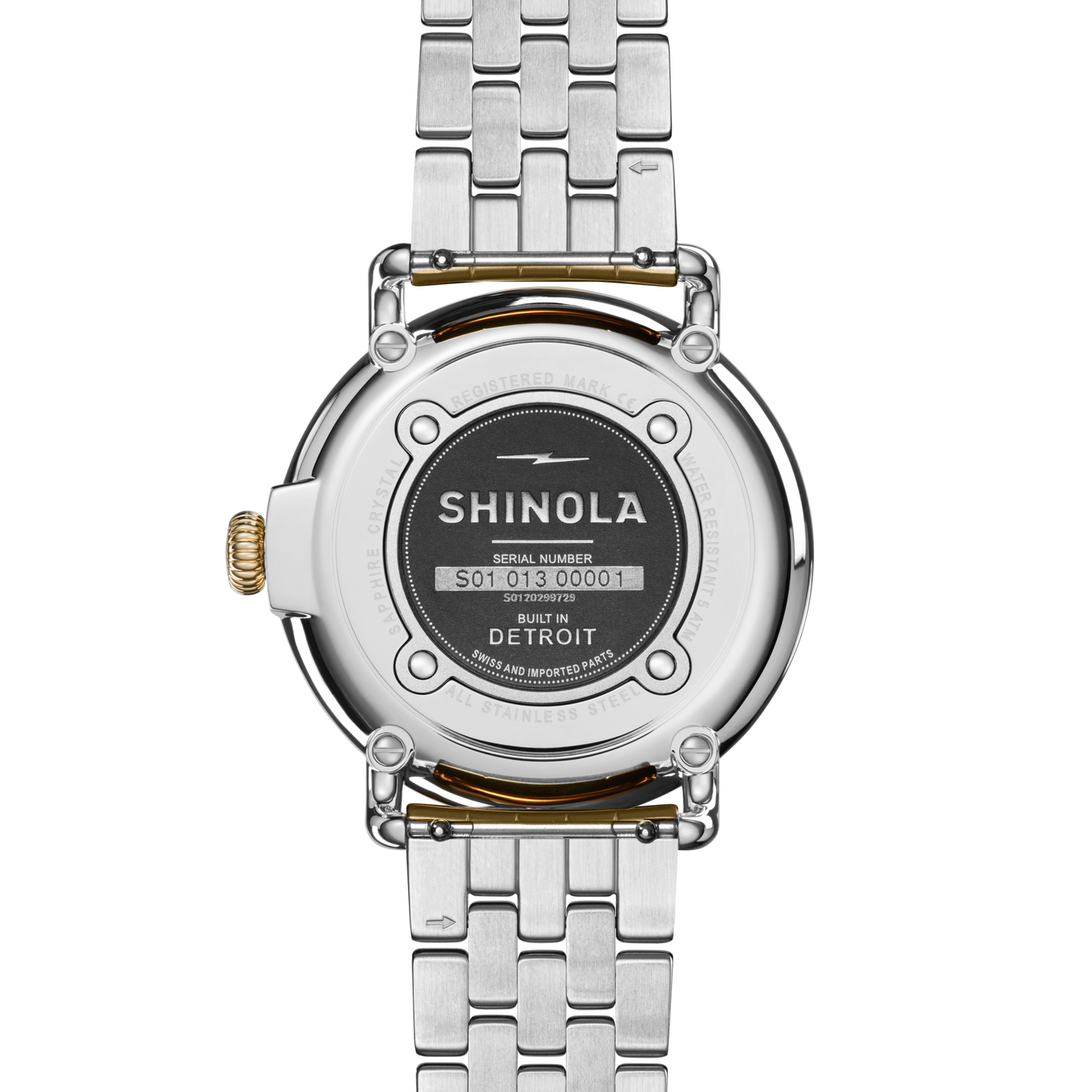A close-up of the back of a Shinola Runwell Watch - Mother Of Pearl with a two-tone stainless steel bracelet. The engraved case back shows the Shinola brand, serial number, and Built in Detroit around a black center plate.
