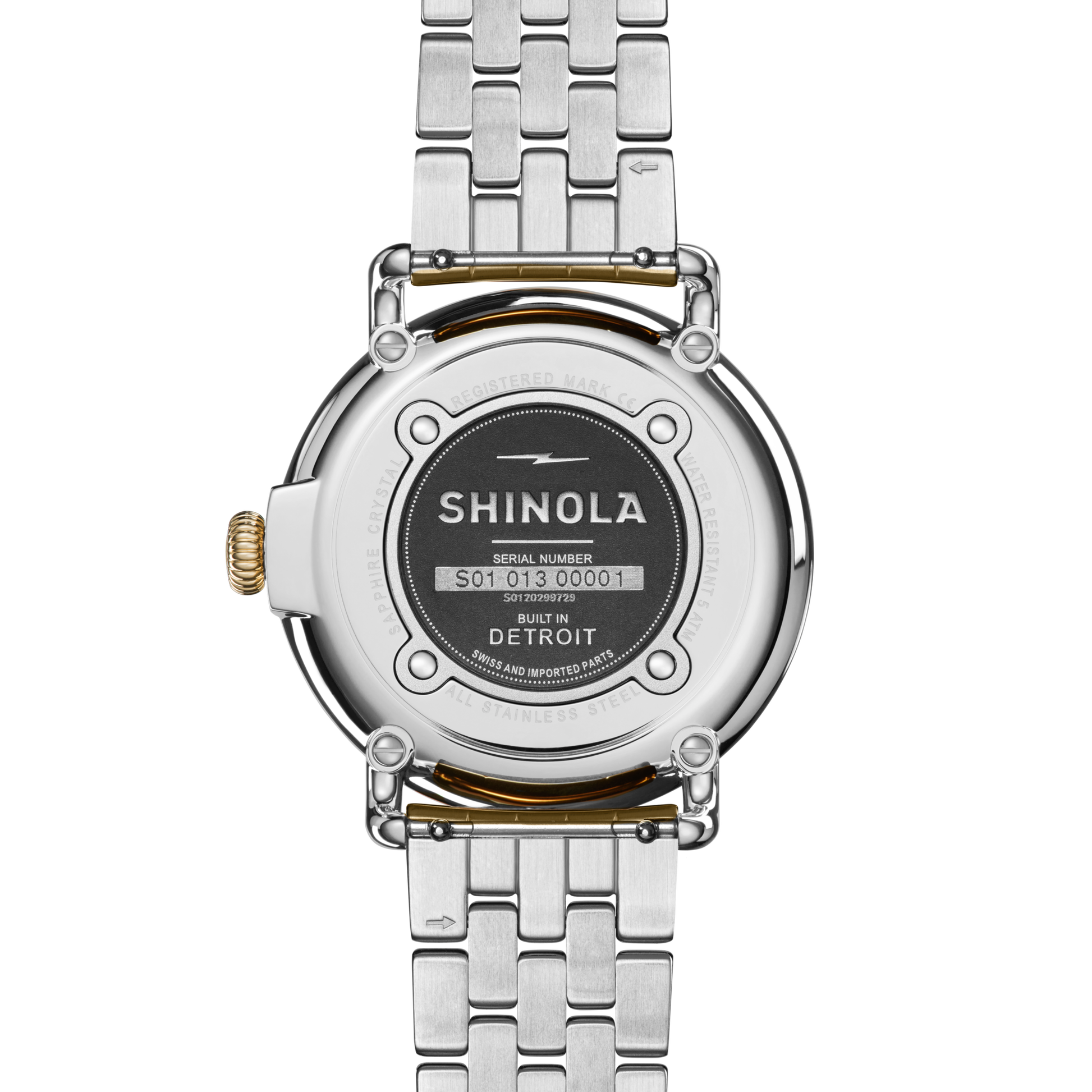 A close-up of the back of a Shinola Runwell Watch - Mother Of Pearl with a two-tone stainless steel bracelet. The engraved case back shows the Shinola brand, serial number, and Built in Detroit around a black center plate.