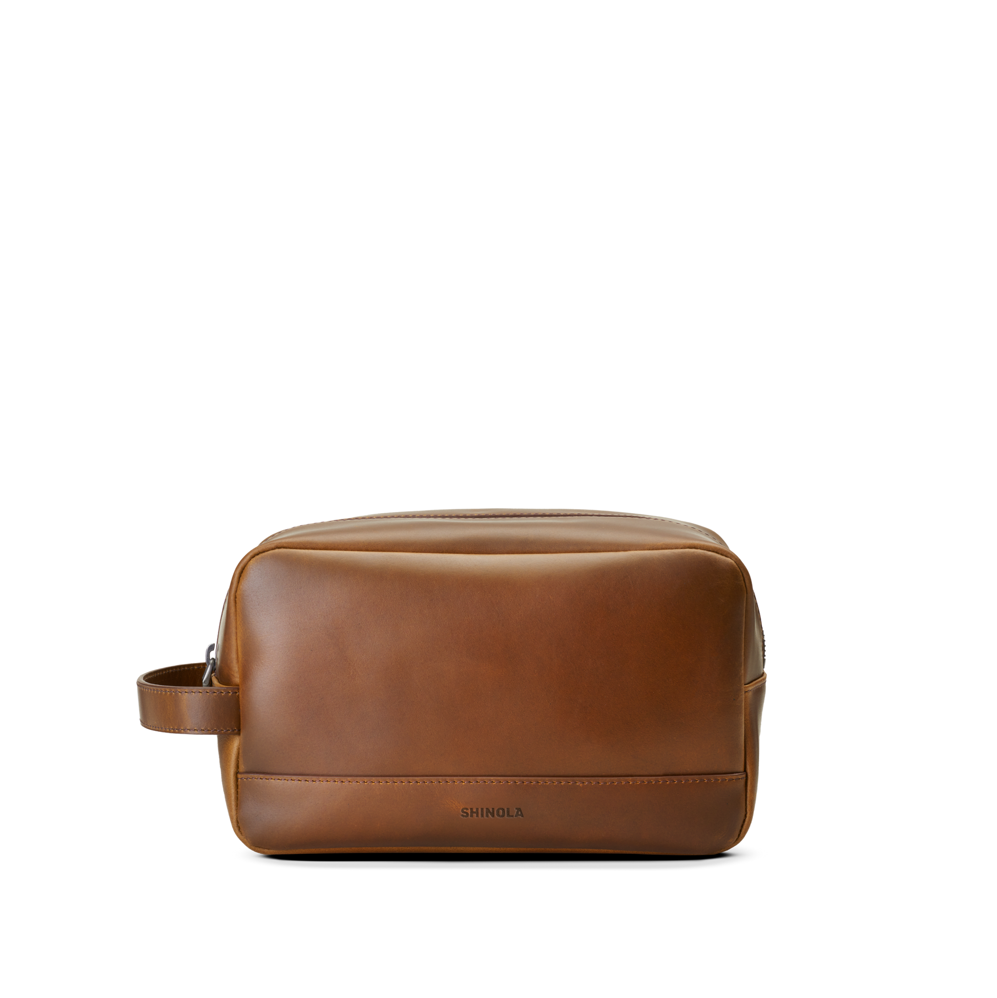 The Zip Travel Kit - Medium Brown by Shinola features navigator leather and a side handle, shown on a plain white background. Shinola’s brand name is subtly embossed near the lower front.