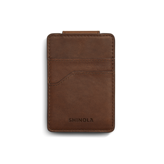 A medium brown Shinola Magnetic Money Clip Card Holder with visible stitching, two credit card slots, and the brand name embossed at the bottom, shown on a white background.