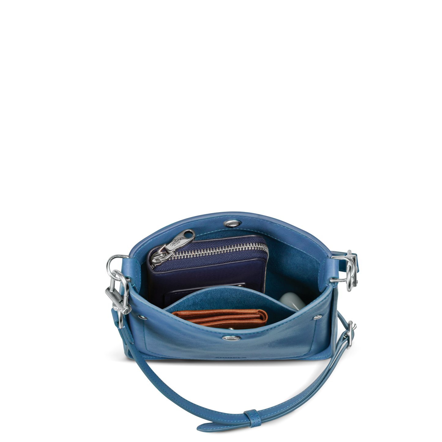 The Shinola Mini Pocket Crossbody Bag - River is a blue leather bag with a shoulder strap, shown open to reveal a zippered wallet, brown cardholder, and small round object—perfect for carrying daily essentials.