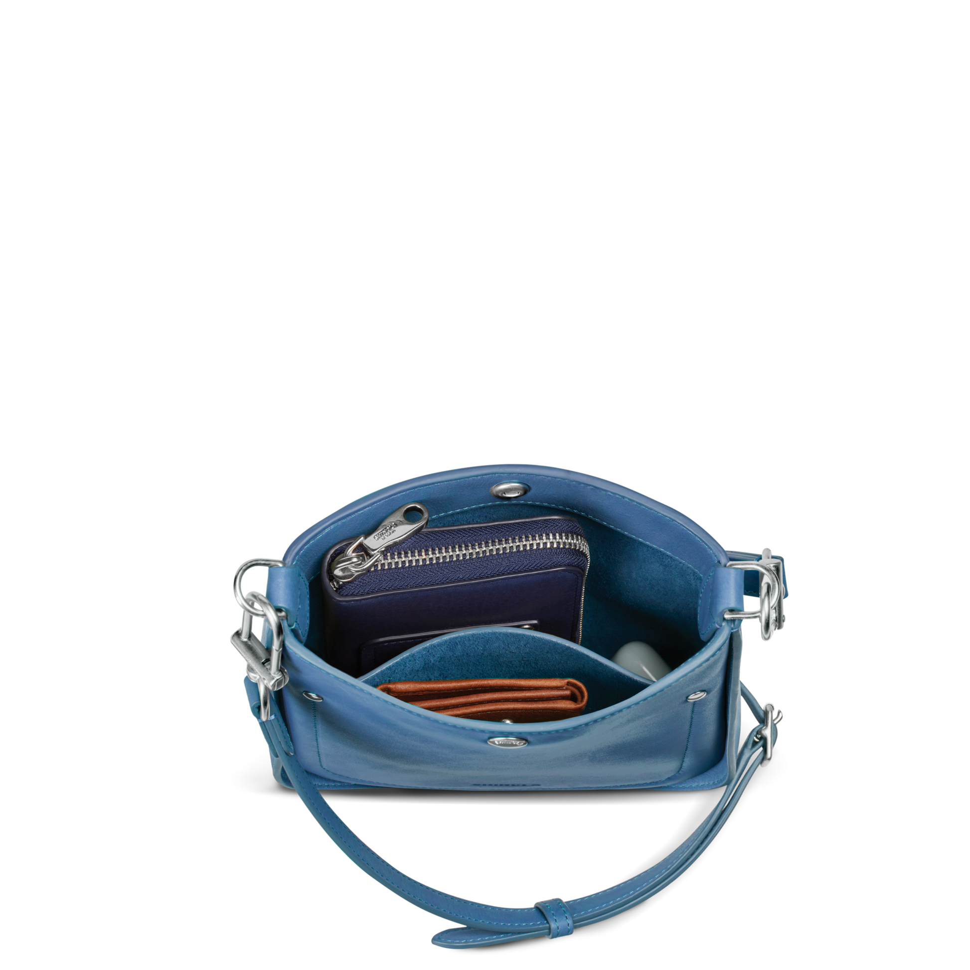 The Shinola Mini Pocket Crossbody Bag - River is a blue leather bag with a shoulder strap, shown open to reveal a zippered wallet, brown cardholder, and small round object—perfect for carrying daily essentials.