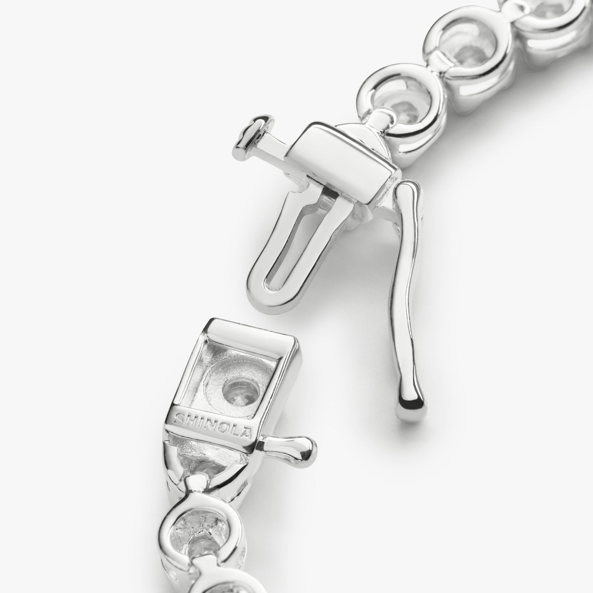 Close-up of the clasp on the Shinola 4 Carat 7" Diamond Tennis Bracelet in white gold, featuring intricate links and a “S 1MM CL” engraving on the box and tongue mechanism.