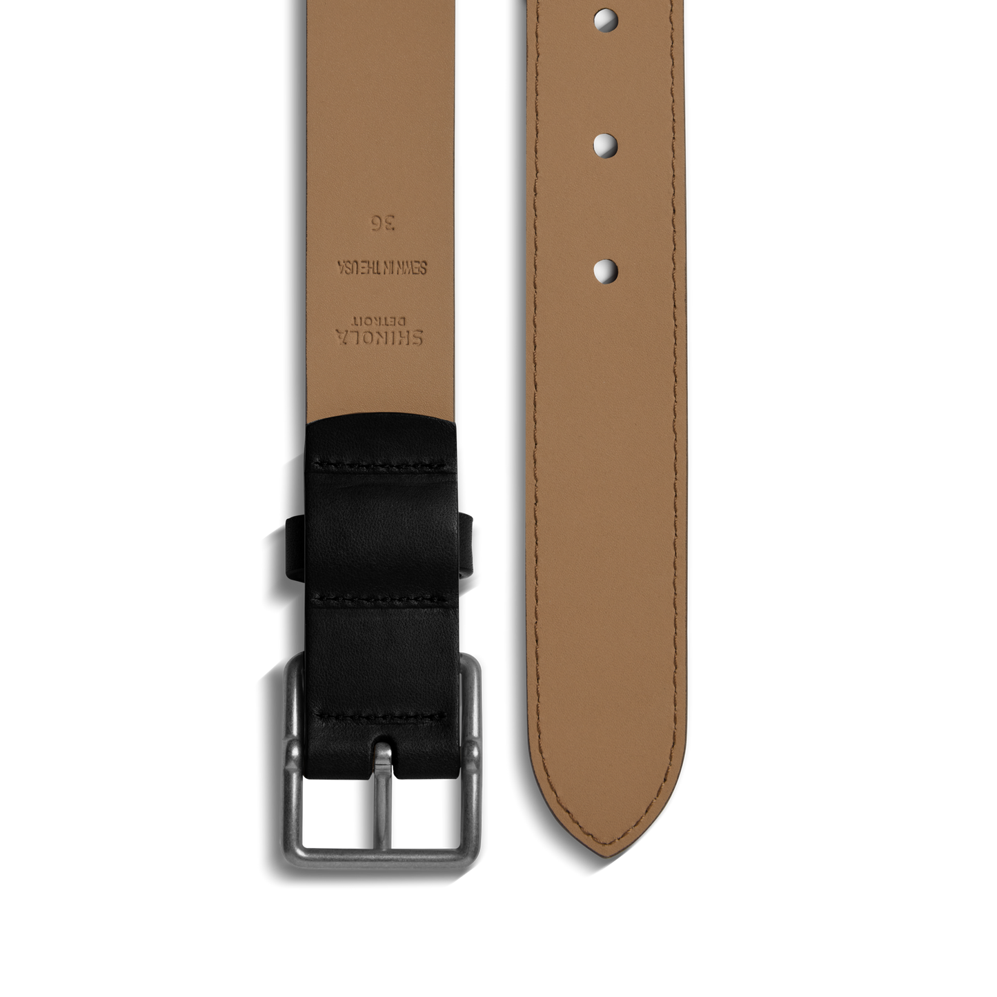 A close-up of the Shinola 1 1/4" Center Bar Buckle Belt in black, crafted from USA Heritage leather, with a black buckle and loop, detailed belt holes, and embossed inner text—a showcase of classic Shinola design.
