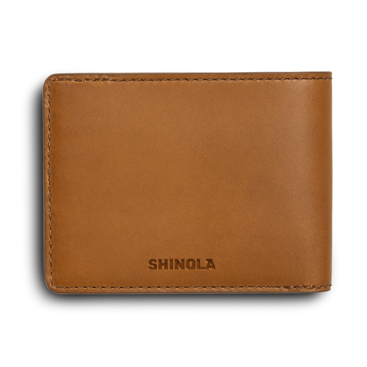 A tan leather Slim Bifold Wallet by Shinola, shown closed with the Shinola logo embossed on the front against a white background.