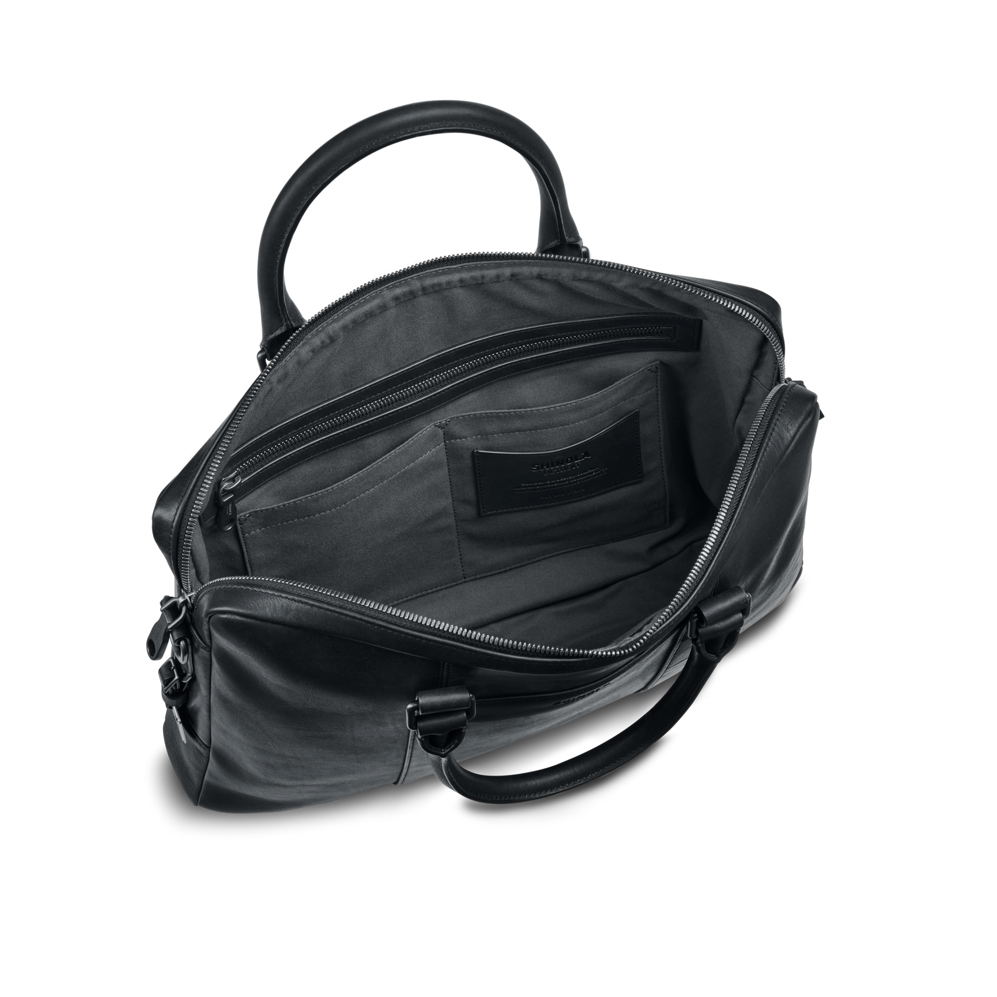 The shinola.momputer Briefcase - Black features two handles and a spacious interior with zippered and slip pockets, making it a stylish work bag. Shown open against a plain white background.