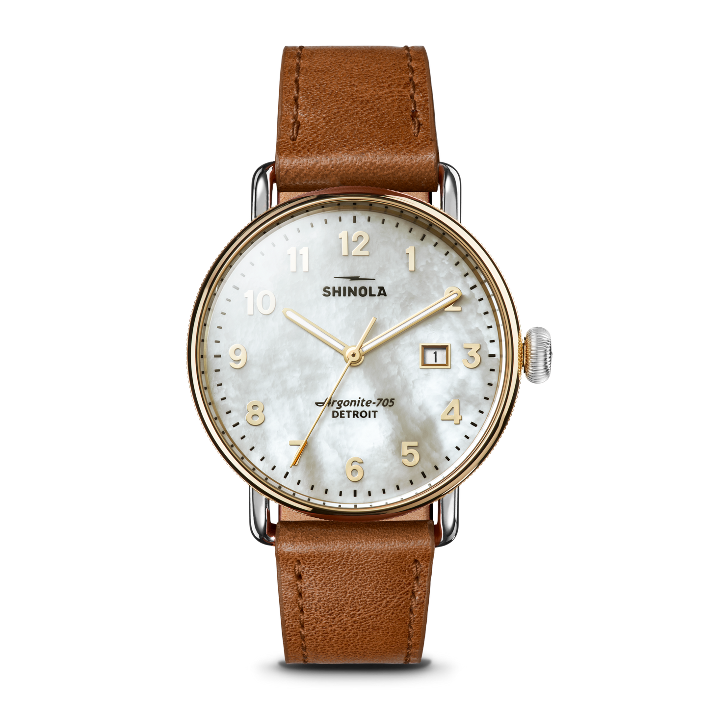The Shinola Canfield Watch features a tan leather strap, round gold-tone case, white mother-of-pearl dial with gold numerals, and a date window at 3 o’clock. The face displays “Shinola” and “Argonite-705, Detroit.”.