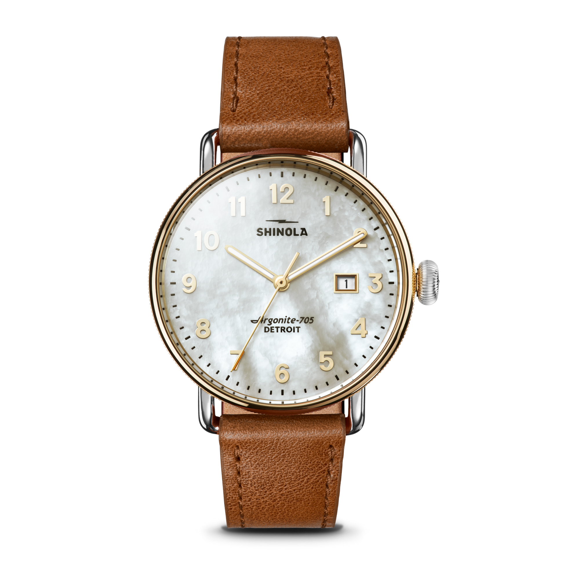 The Shinola Canfield Watch features a tan leather strap, round gold-tone case, white mother-of-pearl dial with gold numerals, and a date window at 3 o’clock. The face displays “Shinola” and “Argonite-705, Detroit.”.