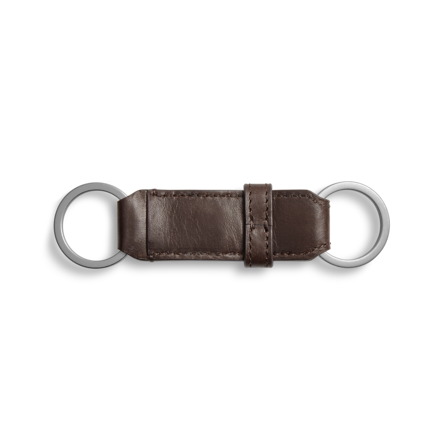 The Shinola Leather Valet Key Fob in dark brown features two silver rings joined by a visible-stitched leather strap and central loop, shown against a white background.