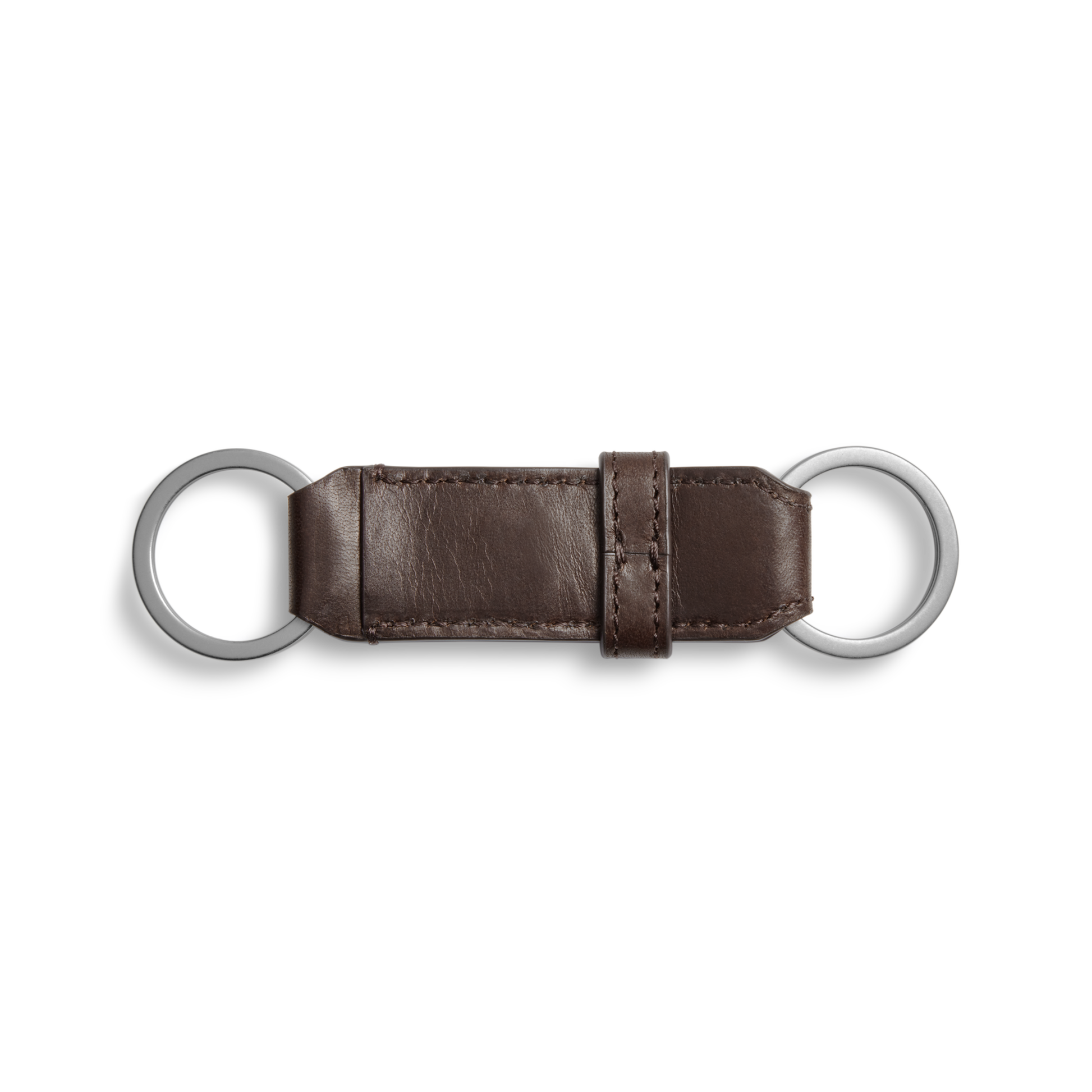 The Shinola Leather Valet Key Fob in dark brown features two silver rings joined by a visible-stitched leather strap and central loop, shown against a white background.