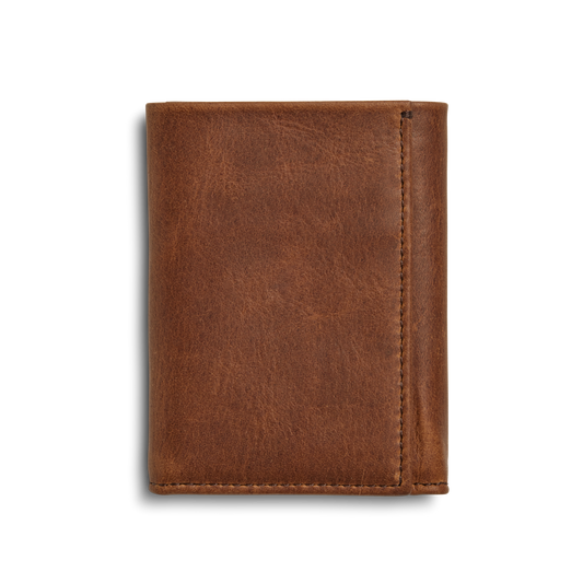 The Shinola Trifold Wallet - Medium Brown features a smooth leather texture, stands upright closed against a white background, and offers RFID protection.
