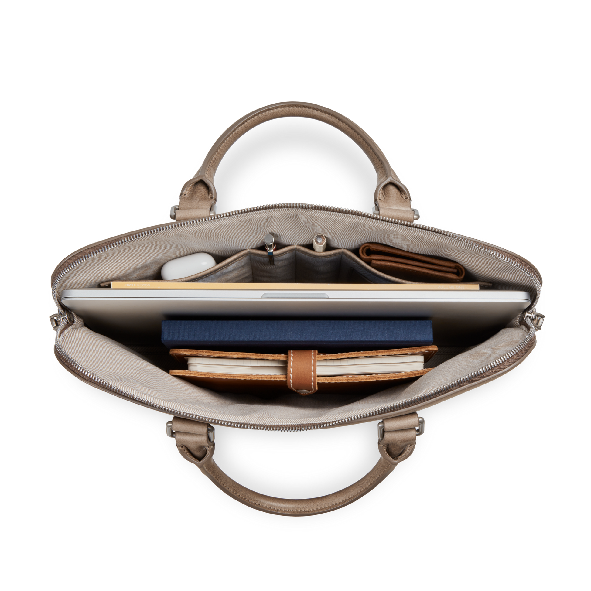 Top view of the Shinola Portfolio Briefcase - Stone, open to reveal organized compartments holding a laptop, notebook, wallet, pens, and small accessories.