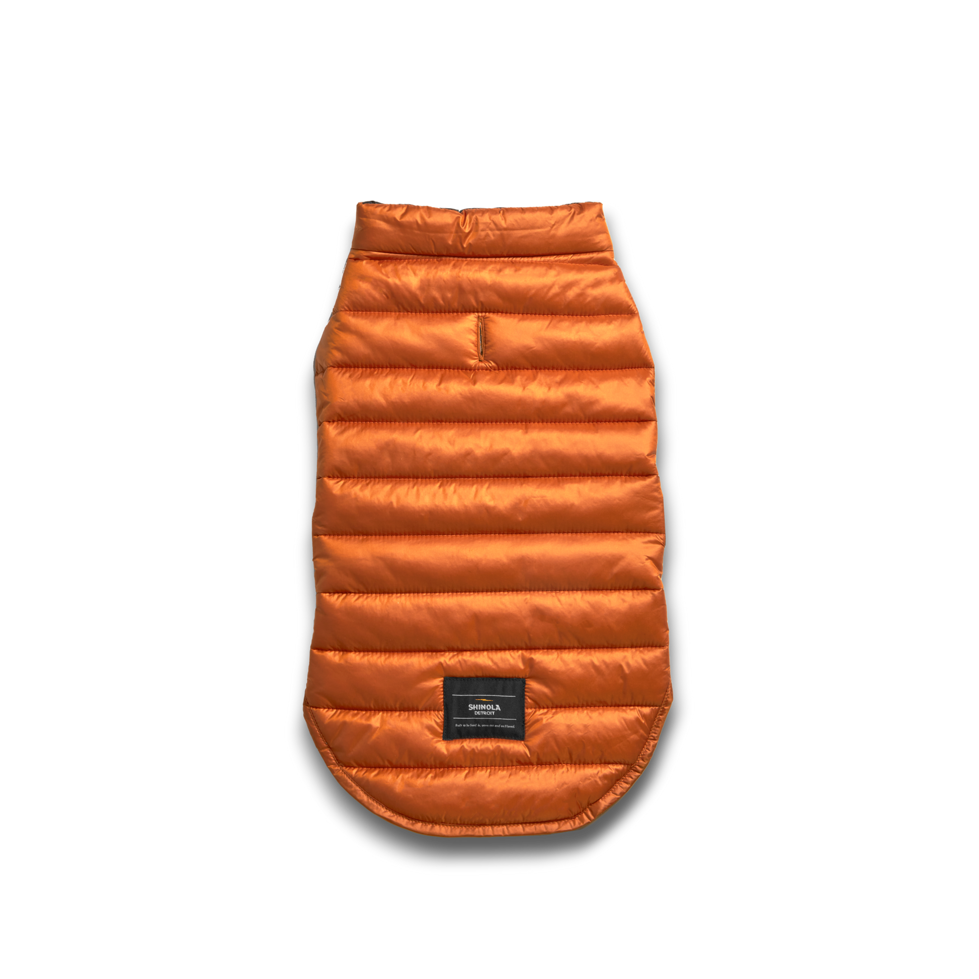 The Shinola Reversible Puffer Dog Coat in Orange/Black is a quilted, warm jacket for dogs, shown flat on a white background with a small black label near the hem.