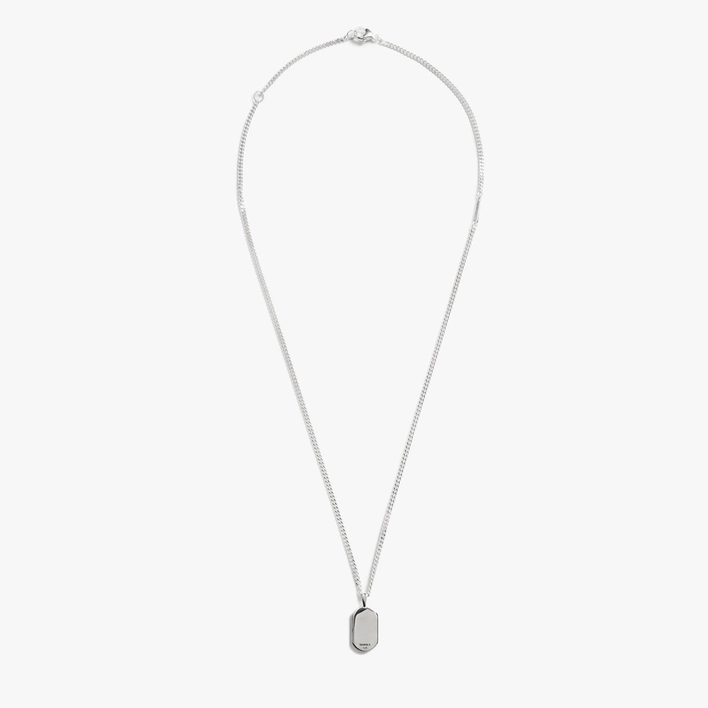 The Shinola Petoskey Tag Necklace in sterling silver features a delicate chain and small rectangular pendant, shown against a white background—a refined piece of unique gemstone jewelry.