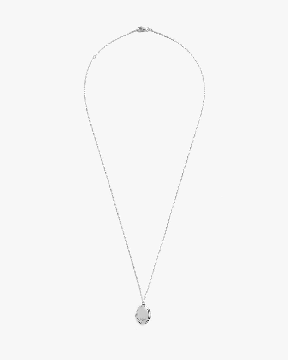 The Heirloom Petite Locket Necklace by Shinola features a delicate sterling silver oval pendant and fine chain, ideal for treasured memories, shown on a plain white background.