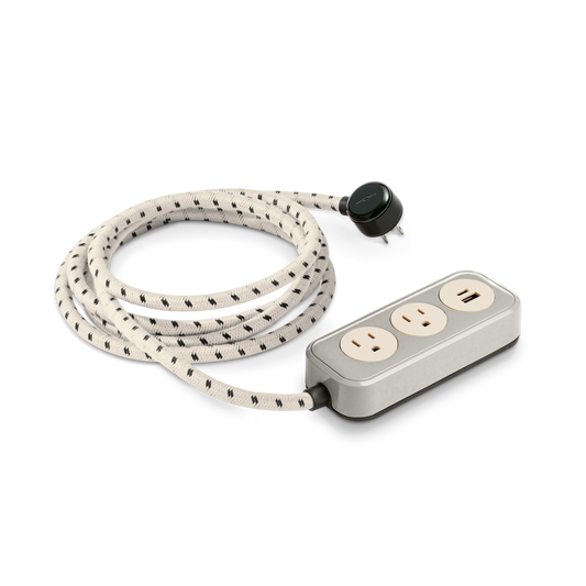 The Shinola 2 Port Power Supply - Stone is a modern power strip featuring two outlets, a USB port, convenient USB-C charging, and a durable long white-and-black braided cord with a round black plug.
