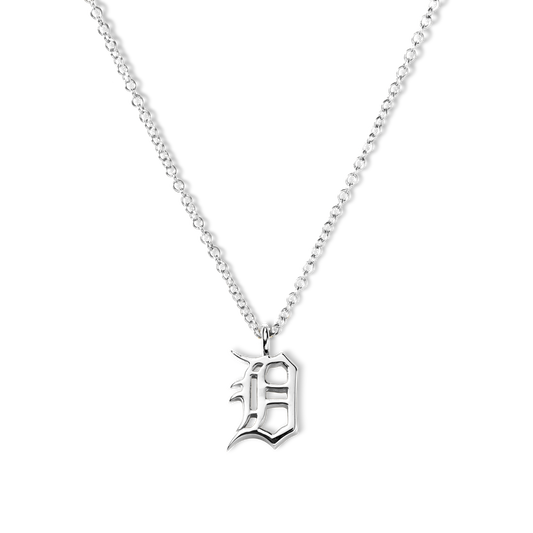 The Shinola Detroit "D" Charm Necklace in sterling silver features a thin chain and an ornate gothic "D" pendant, elegantly displayed against a white background—a stylish nod to classic Detroit jewelry.