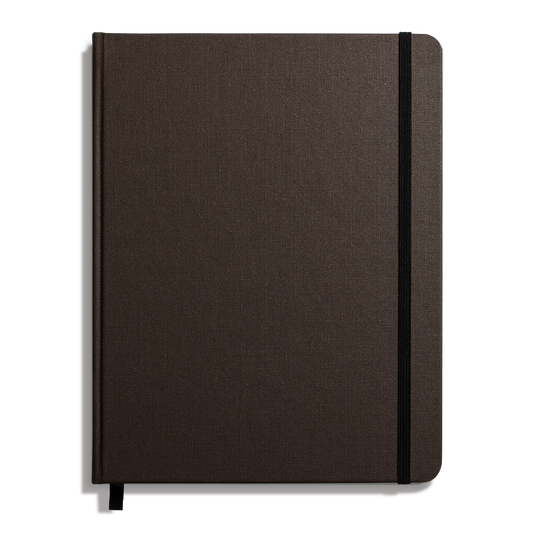 The Shinola Large Hard Ruled Journal in Espresso features a durable closed linen cover, black elastic band on the right edge, and a black ribbon bookmark, offering classic style and lasting quality.