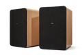 Two rectangular Shinola Bluetooth Bookshelf Speakers - Natural, featuring light wood sides and black fabric fronts with a centered logo, are placed side by side against a white background.