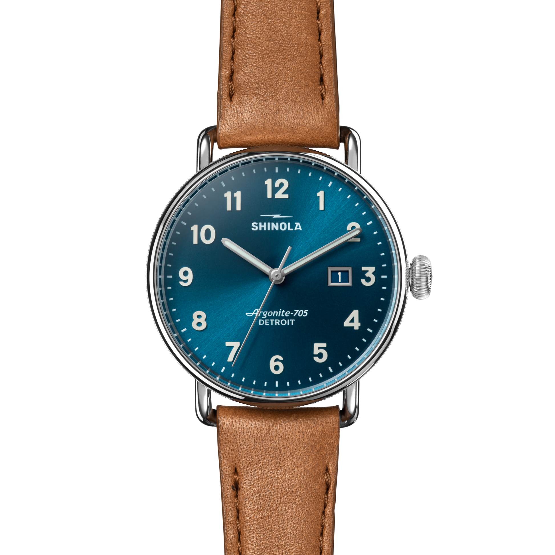 The Shinola Canfield Watch features a blue dial, tan leather strap, stainless steel case, white numerals, and silver hands. It has a precise Argonite 705 movement and a date window at 3 o’clock.