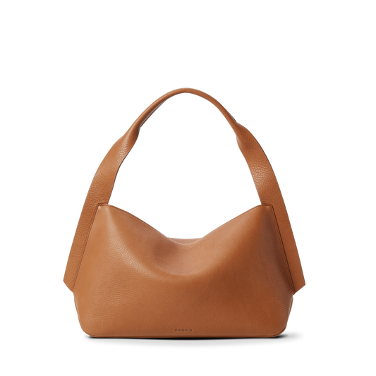 The Shinola Medium Derby Shoulder Bag - Tan, made from natural grain leather with wide rounded handles and a relaxed hobo silhouette, is shown on a plain white background.