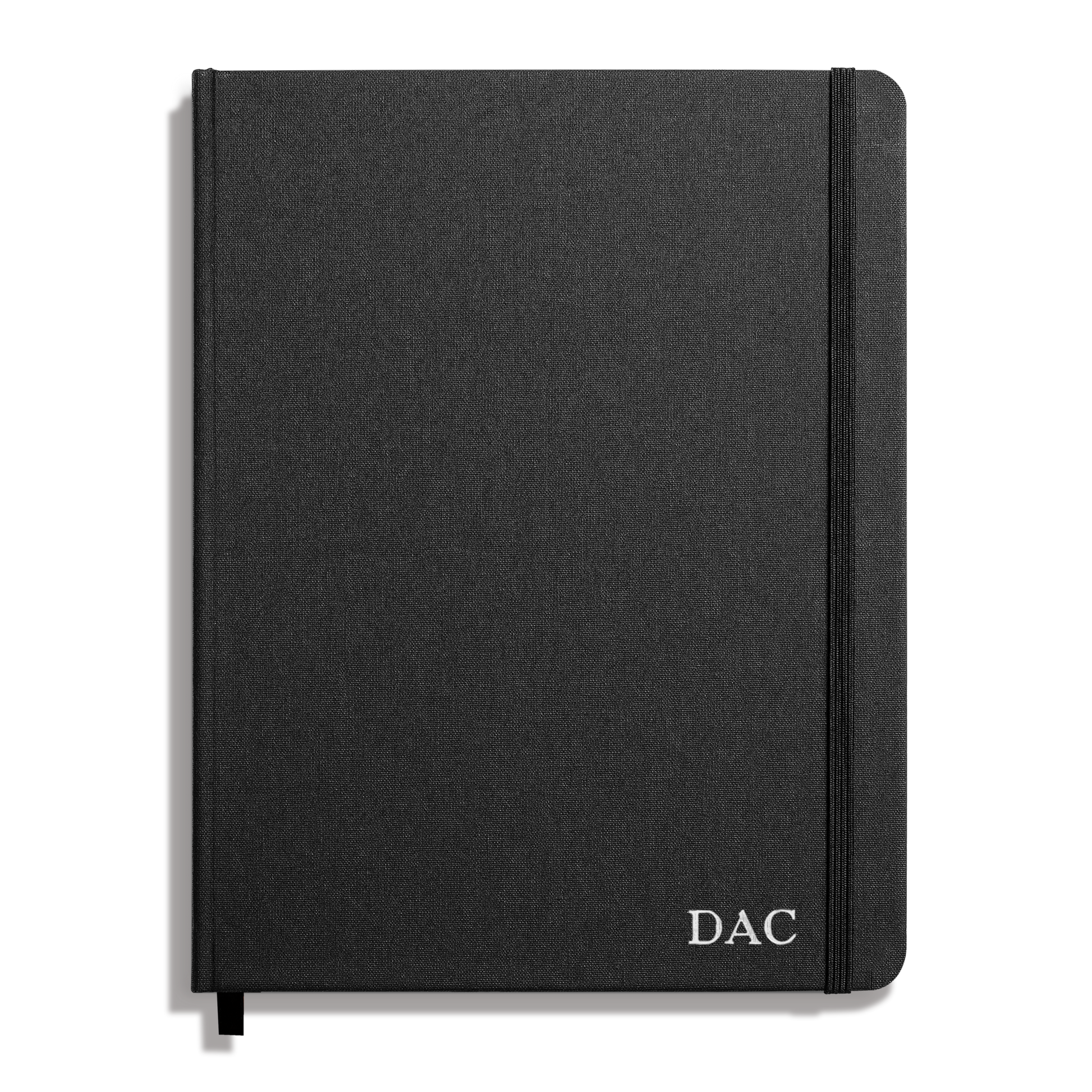 The Shinola Large Hard Grid Journal in black features a closed hard linen cover with smyth-sewn binding, an elastic band closure, and “DAC” initials printed in white on the bottom right corner.