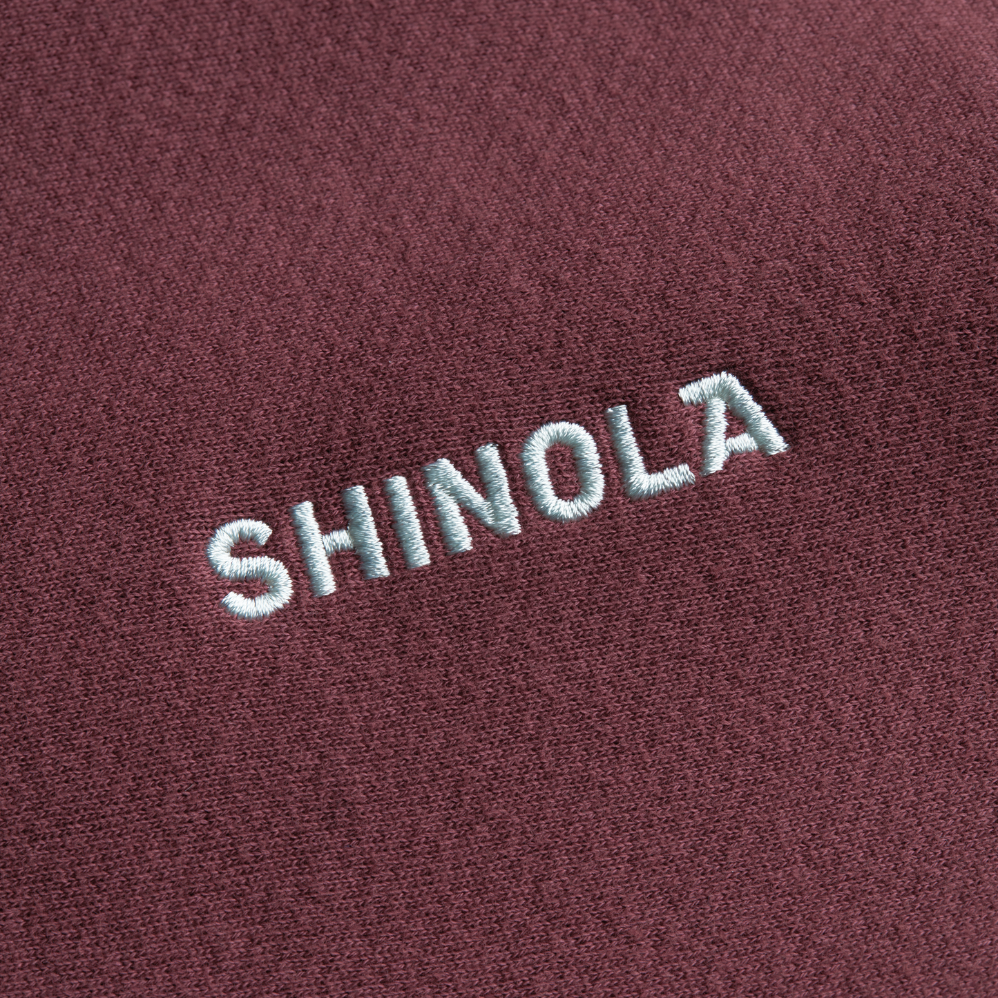 The Shinola Fleece Logo Sweatshirt - Merlot features embroidered white SHINOLA text on maroon American cotton fleece and offers a unisex classic fit.