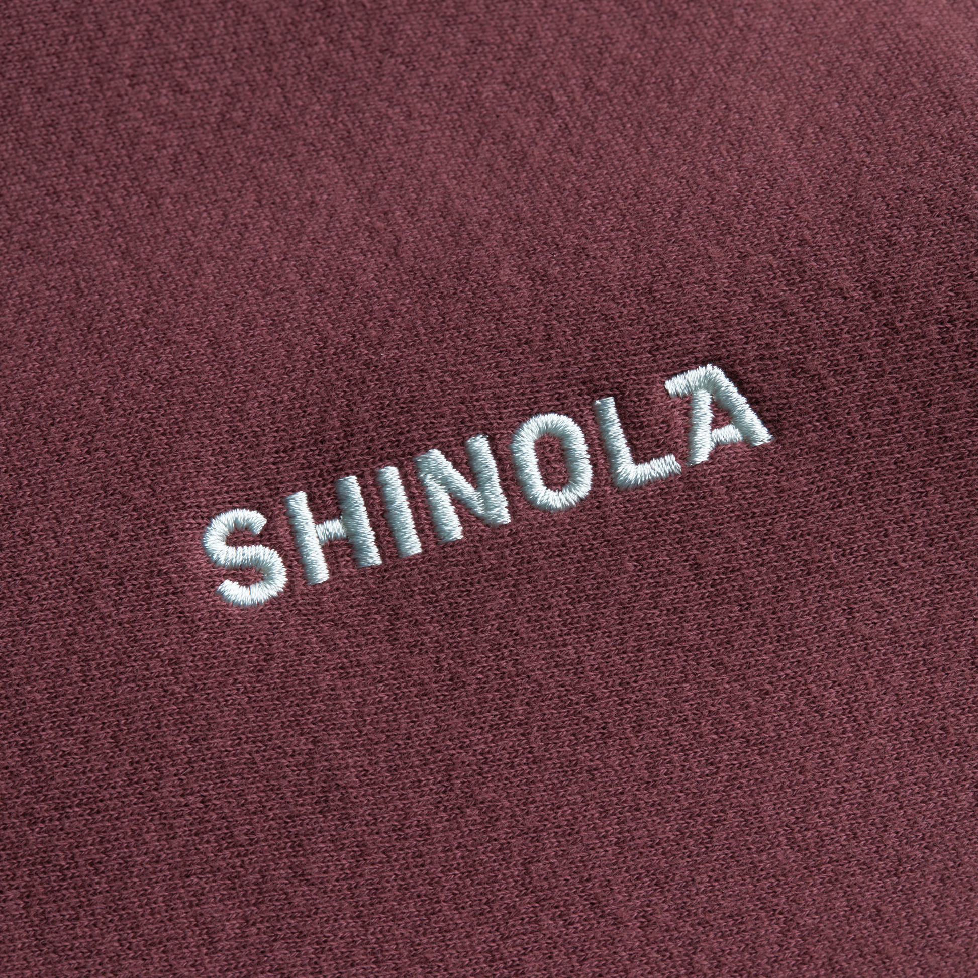The Shinola Fleece Logo Sweatshirt - Merlot features embroidered white SHINOLA text on maroon American cotton fleece and offers a unisex classic fit.