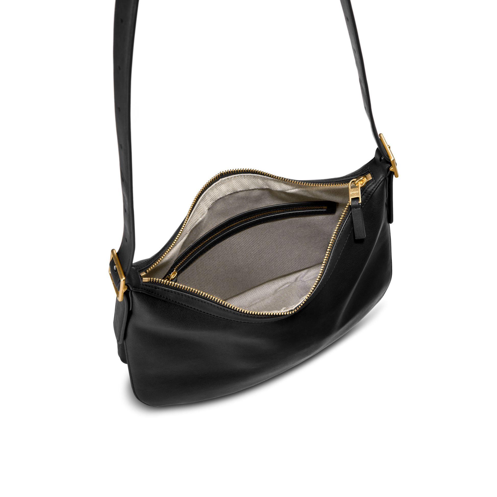 The Shinola Medium Bixby Crossbody in black natural leather features gold hardware, a light beige fabric lining, and an interior zip pocket—a stylish and versatile accessory for any occasion.