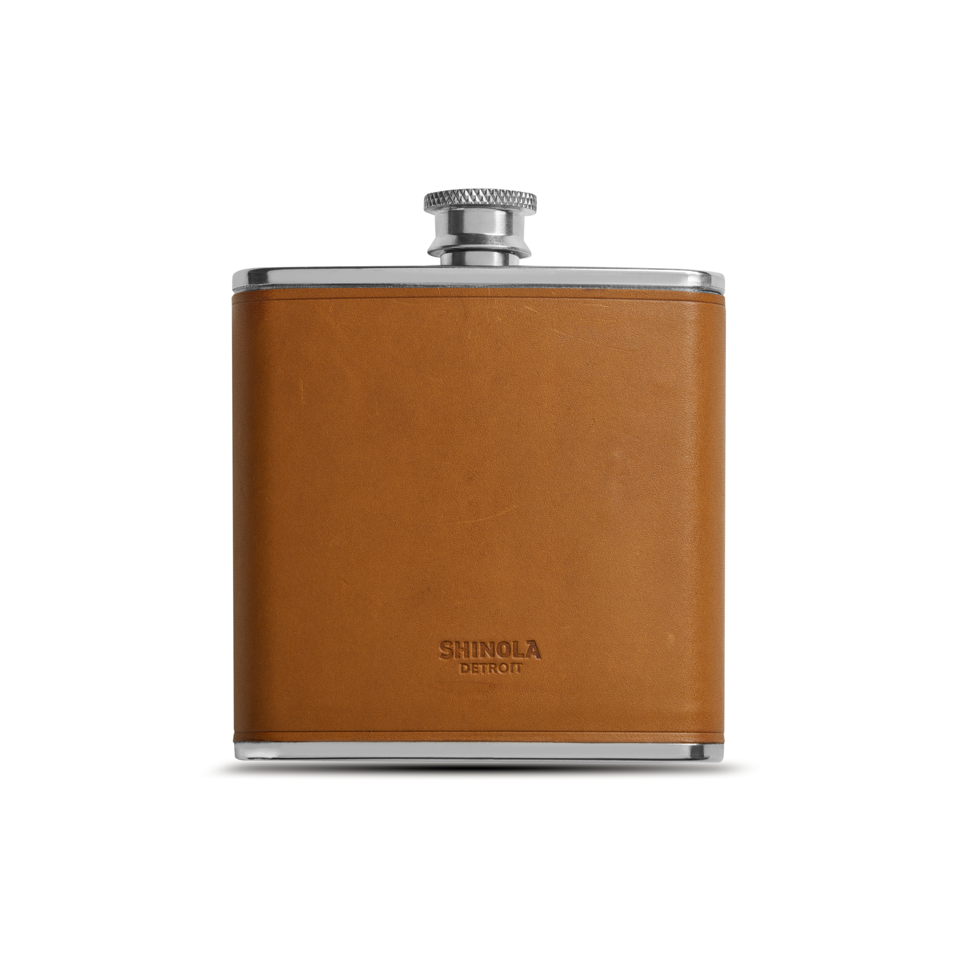 The Leather Wrapped Flask - Tan by Shinola features a stainless steel body with a tan Italian Vachetta leather wrap and screw cap, the Shinola name embossed on the front, displayed against a plain white background.