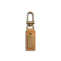 The Shinola Birdy Keychain - Honey features tan leather and a rectangular gold metal plate with a gold swivel clasp, shown on a white background—ideal as an engravable key fob for a personalized touch.