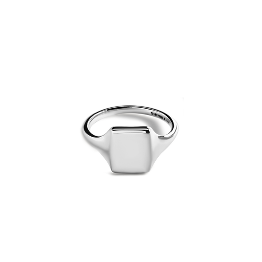 The Shinola Petite Rectangular Signet Ring, crafted in sterling silver, is displayed against a white background. Its smooth rectangular face and subtly engraved interior make this monogrammed ring timeless and personal.