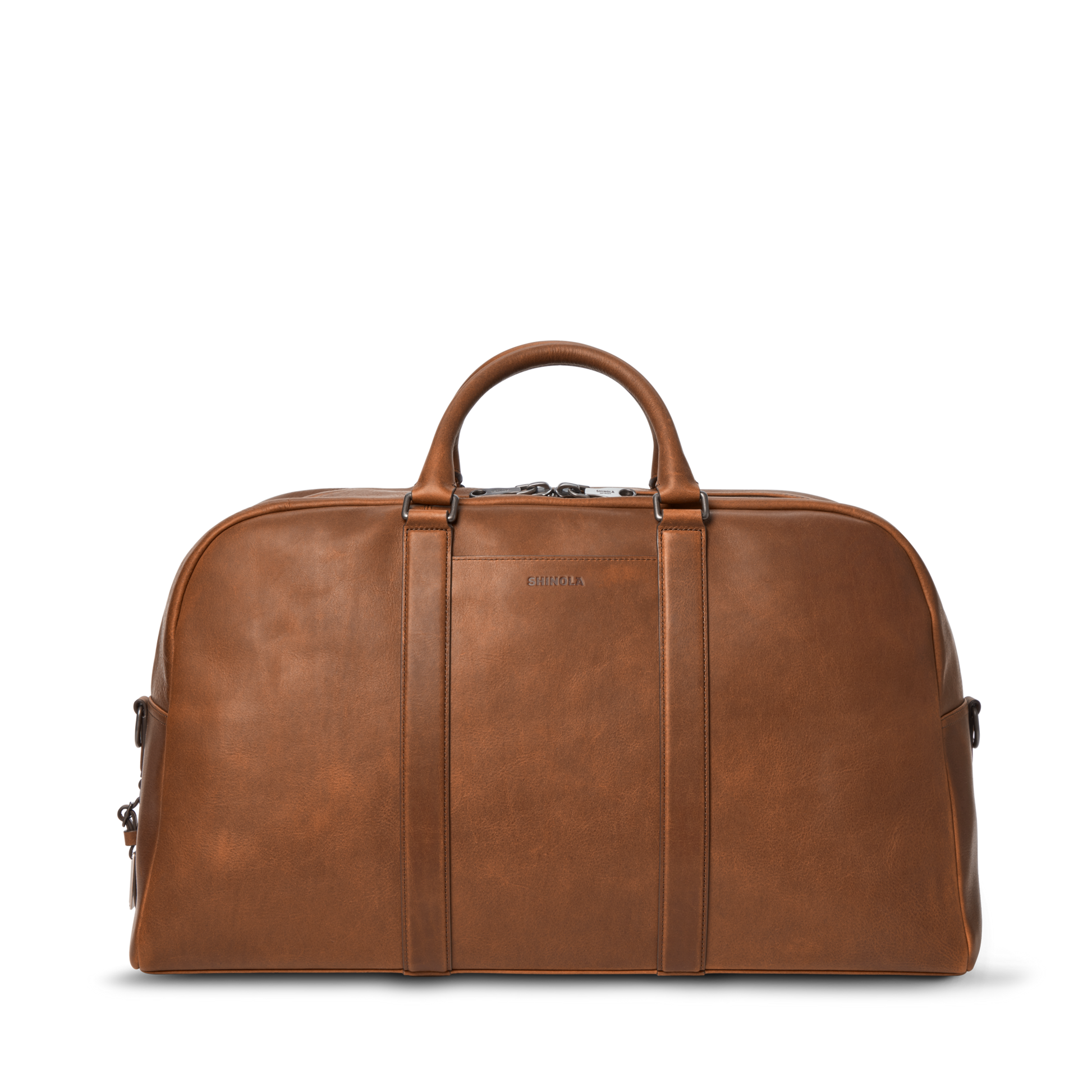 The Shinola Runwell Duffle Bag in Medium Brown, crafted from premium leather, has two short handles, a zipper closure, and a minimal design—ideal as a carry-on—shown against a plain white background.