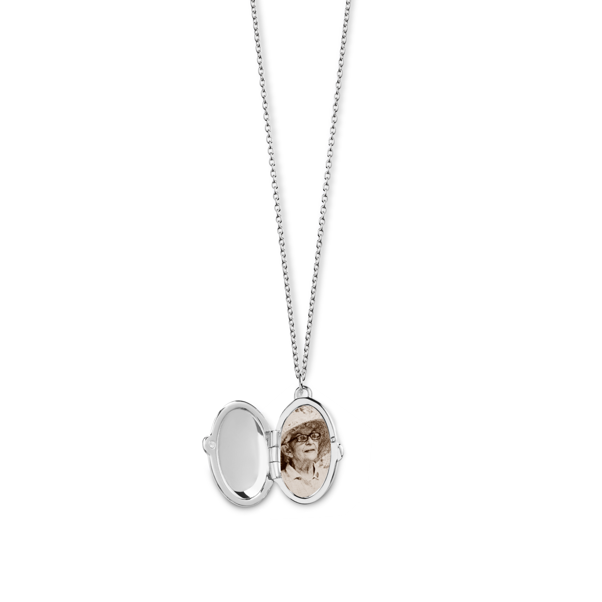 The Shinola Heirloom Statement Locket Necklace in sterling silver hangs open, showing a mirror on one side and a sepia photo of a person with glasses and a hat on the other, set against a plain white background.